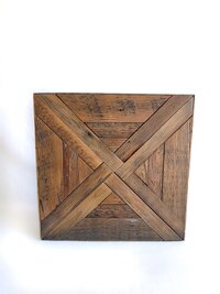 May include: A square wooden wall art piece constructed from reclaimed planks arranged in a geometric pattern. The design features two intersecting diagonal strips forming an X shape, surrounded by vertical and horizontal wood grain textures.
