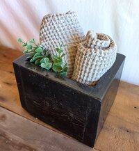 Handmade rustic wooden organizer caddy crafted from reclaimed wood, styled with rolled washcloths and greenery for farmhouse bathroom countertop storage.